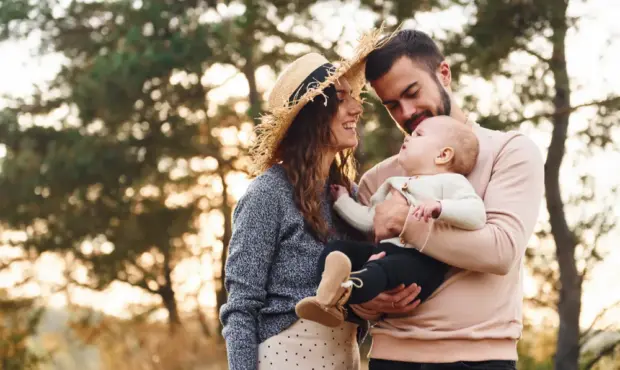 Eltern posieren mit Baby in der Natur