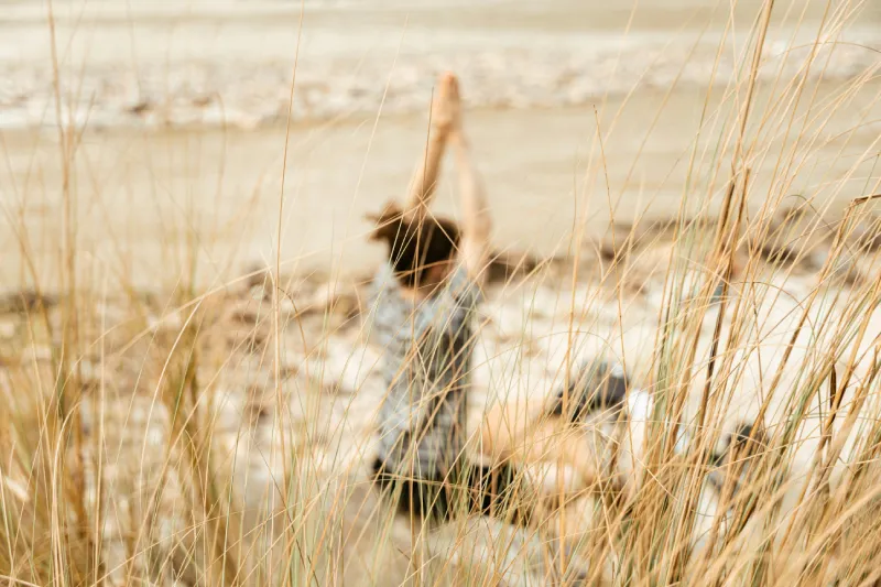 Frau macht Yoga am Strand