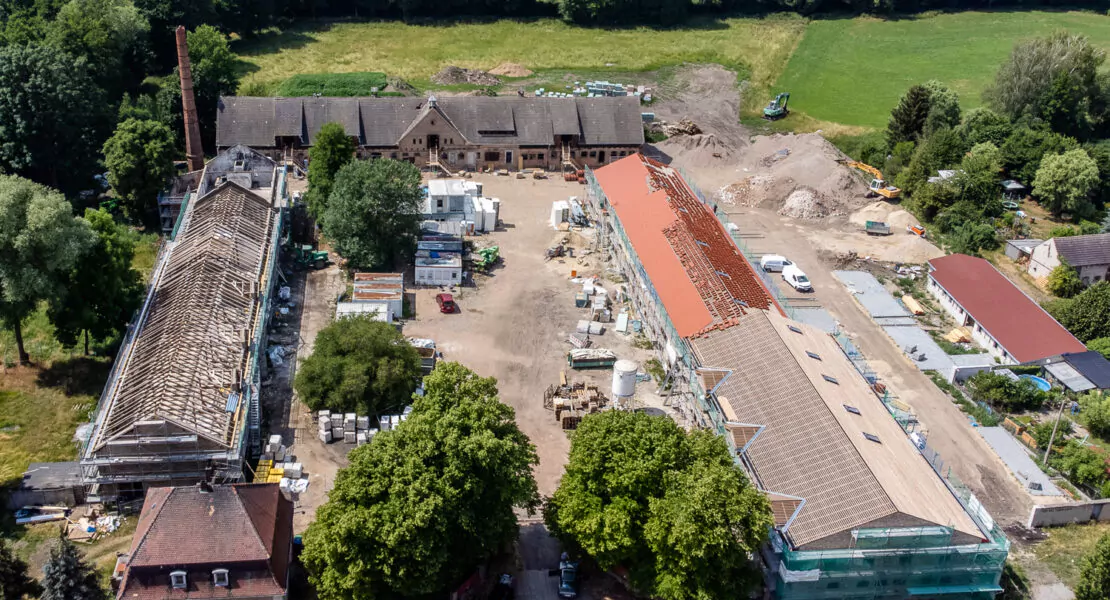 Von grünen Wäldern umgebene Baustelle des Klosters Zinna aus der Vogelperspektive