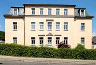 Bestandsimmobilie Freital, Außenansicht des Mehrfamilienhauses mit Hecke