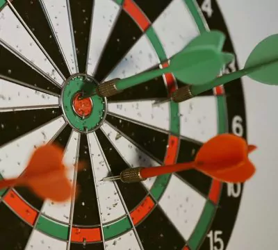 Dartscheibe mit zwei roten und zwei grünen Dartpfeilen