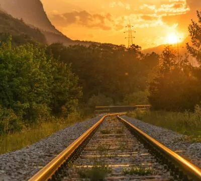 Bahngleise umgeben von Natur bei Sonnenuntergang