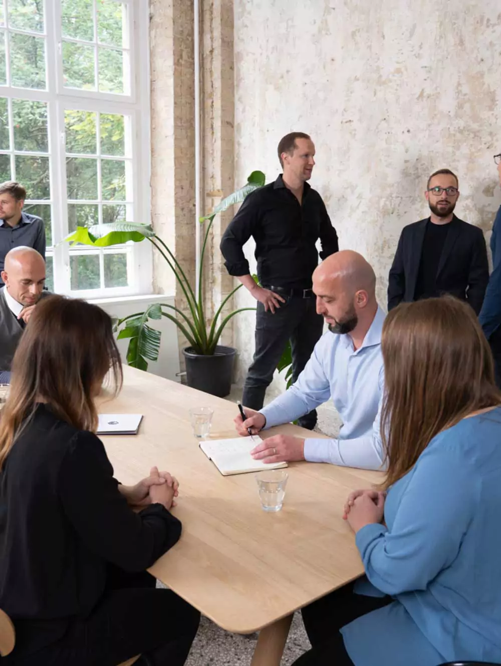 das Team der CAPRI CONSULT versammelt in einem lichtdurchfluteten Raum
