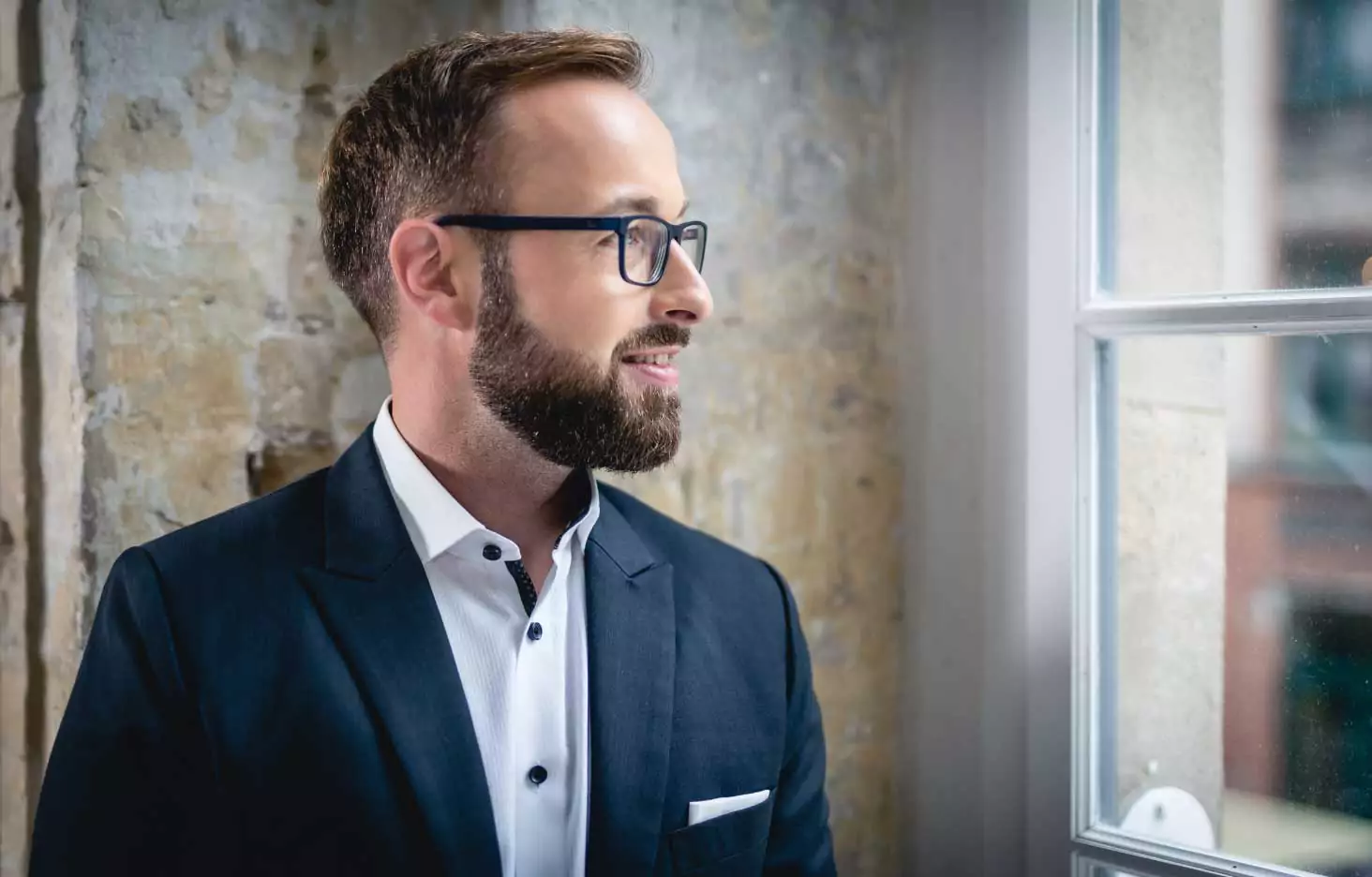 Fabian Schuster, lächelnd mit Blick aus dem Fenster
