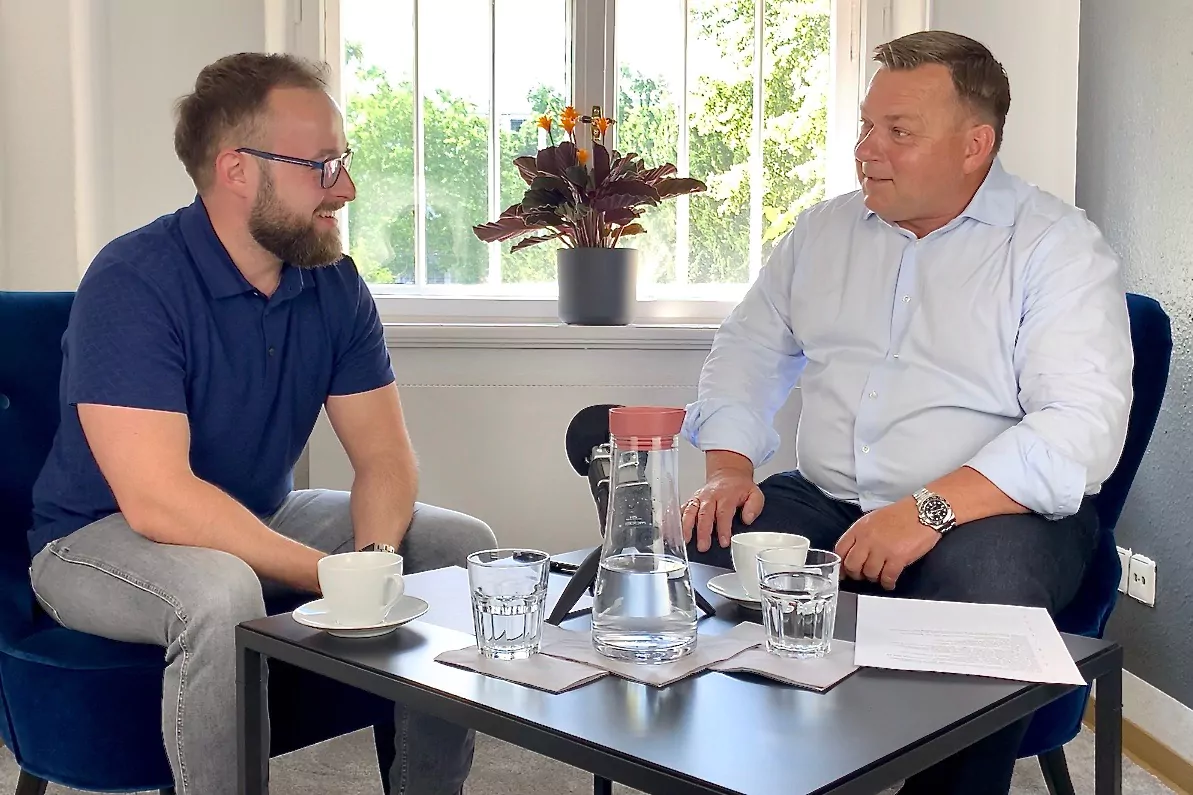 Fabian Schuster (links) und Guido Maihack (rechts) gemeinsam an einem Tisch sitzend