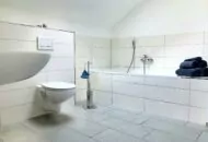 Ferienimmobilie Rügen, Innenansicht des hellen Badezimmers ausgestattet mit Badewanne