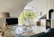 Ferienimmobilie Rügen, Innenansicht Wohnbereich und Balkon ausgestattet mit Kamin