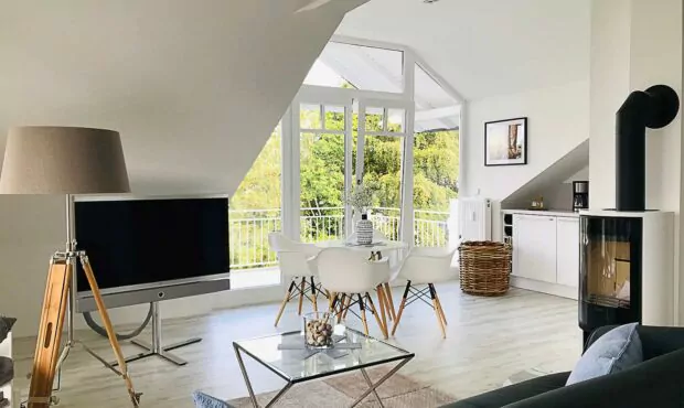 Ferienimmobilie Rügen, Innenansicht Wohnbereich und Balkon ausgestattet mit Kamin