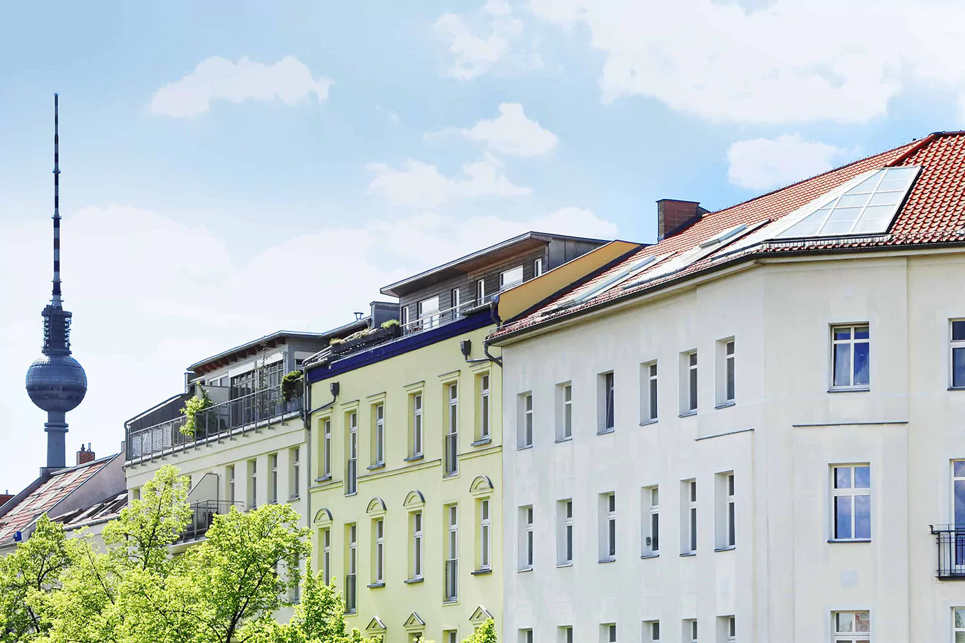 Reihe aus Mehrfamilienhäusern mit Fernsehturm im Hintergrund
