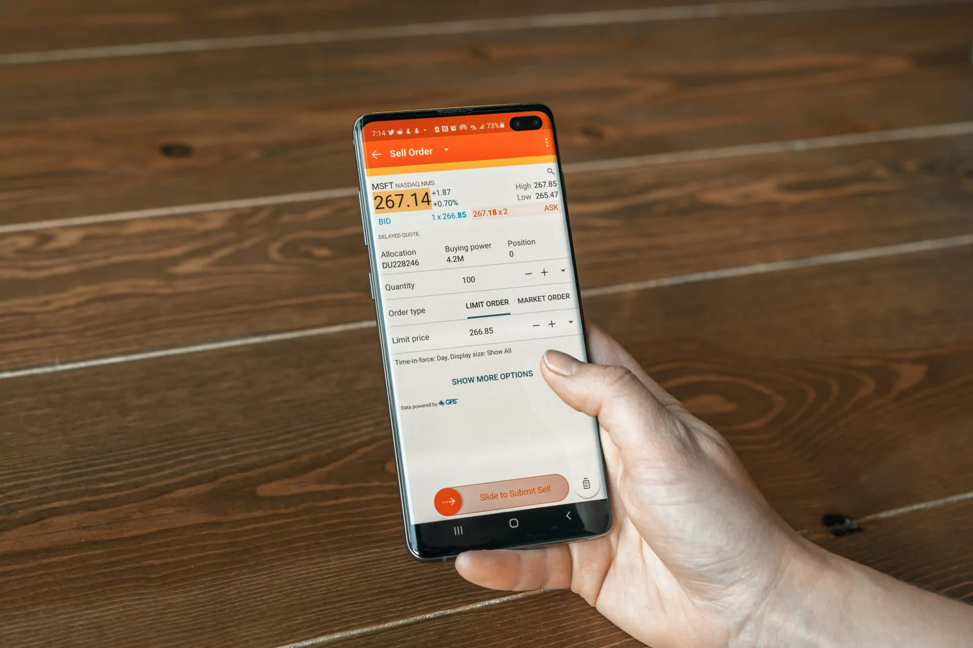 Person hält ein Smartphone, auf dem der Kurs der Microsoft-Aktie zu sehen ist ist