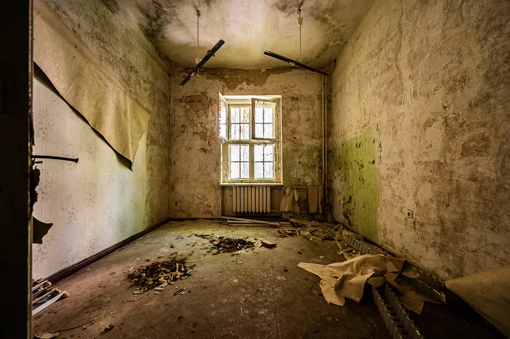 sanierungsbedürftiges Zimmer mit einem Fenster in einem Altbau