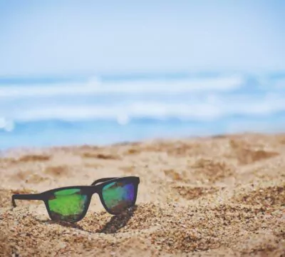 Eine Sonnenbrille liegt am Strand
