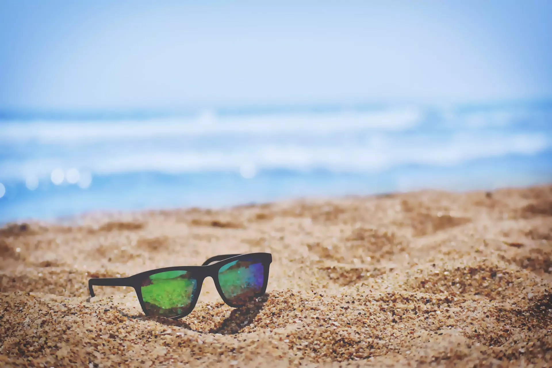 Eine Sonnenbrille liegt am Strand