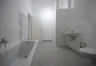 Sanierter Wohnraum weiß gefliestes Bad mit Badewanne