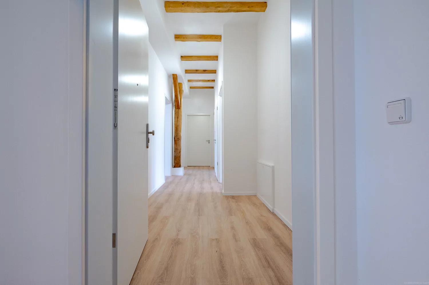 Sanierter Wohnraum Hausflur mit Deckenbalken und freistehendem Holzbalken