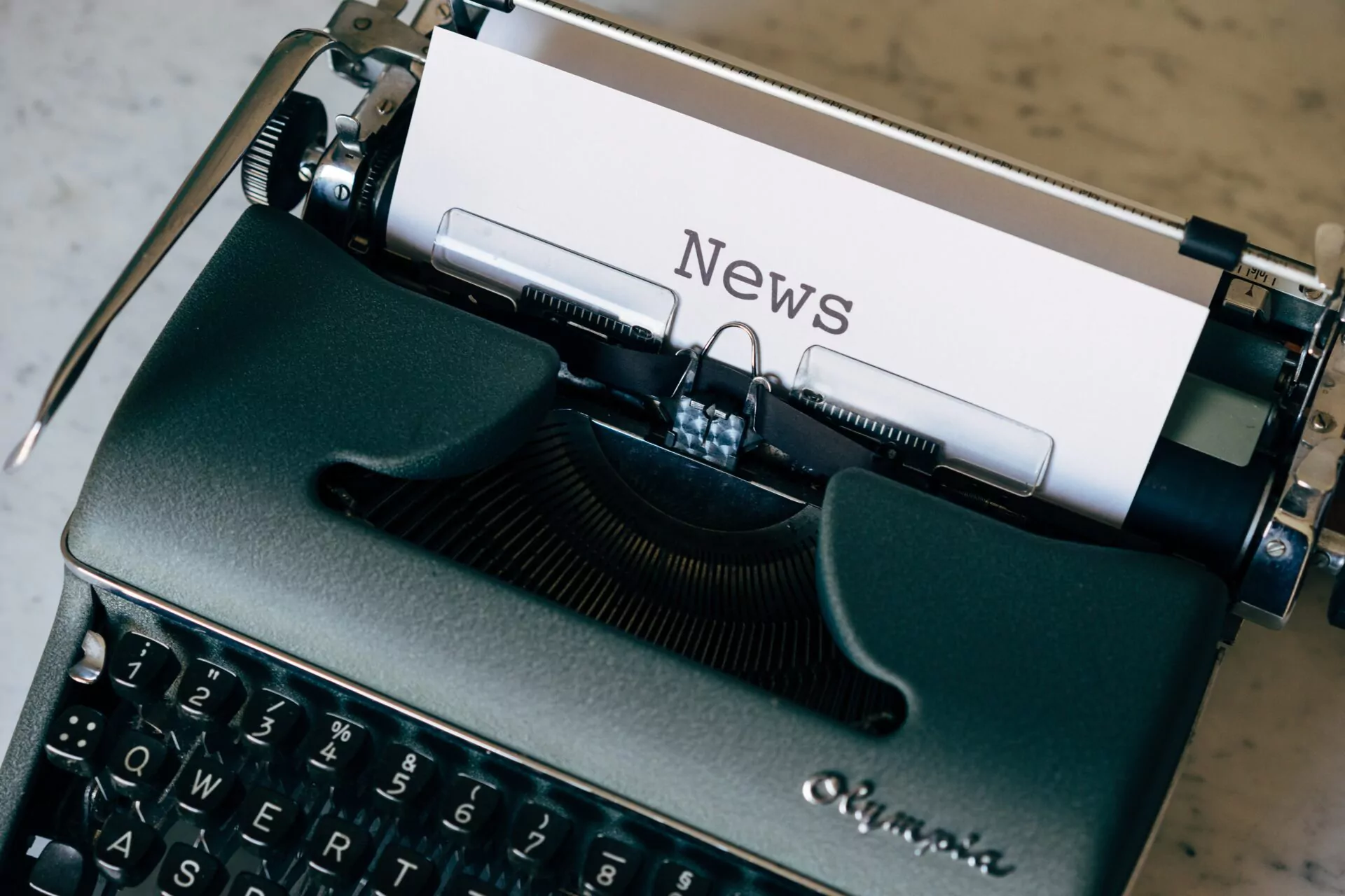 Das Bild zeigt eine Schreibmaschine mit einem Blatt wo draufsteht:News