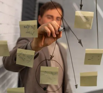 Ein Mann brainstormt an einer Glastafel